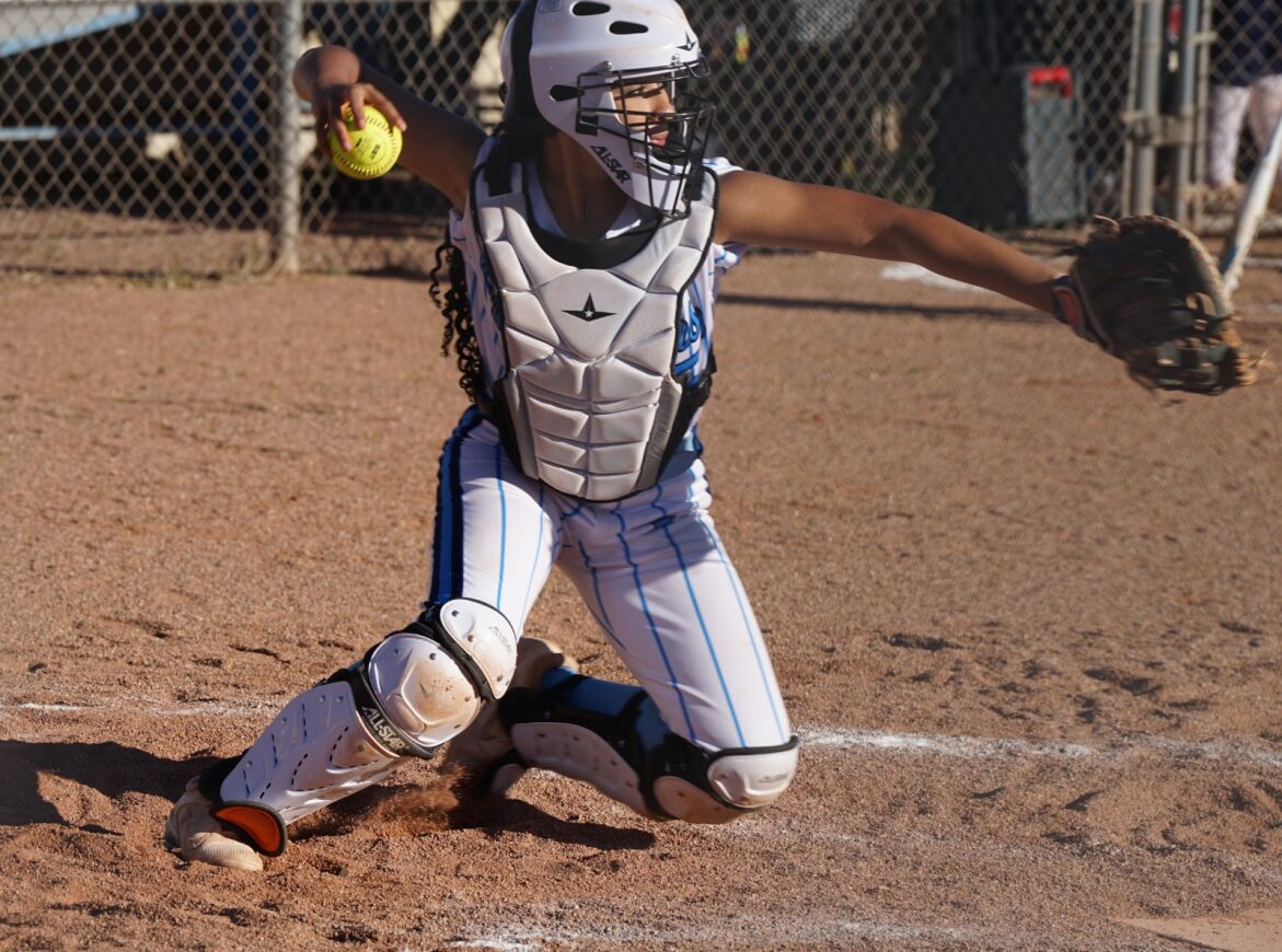 The Pueblo softball catcher throws the ball back to the pitcher