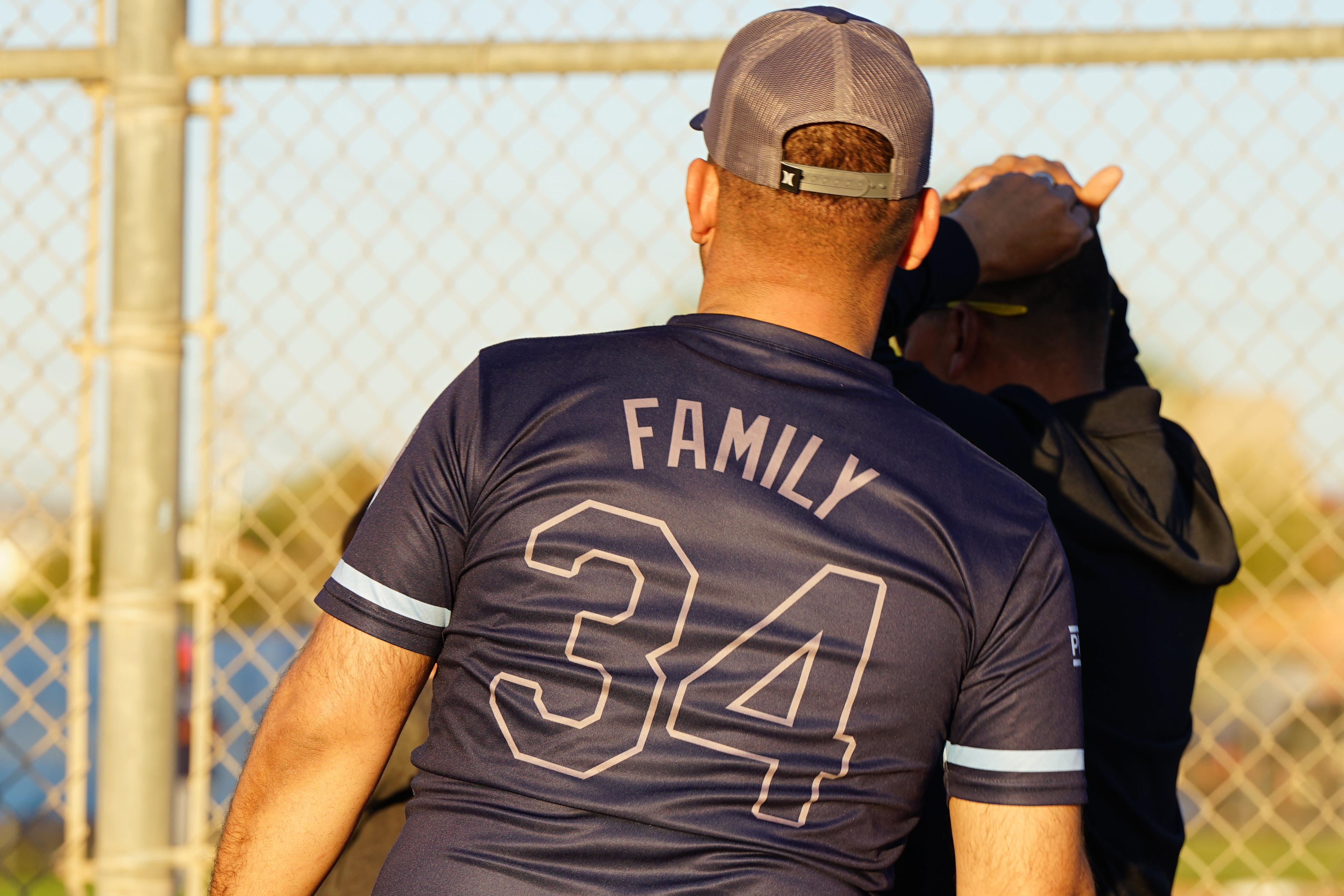 A man in a jersey with the name Family on the back watches the game