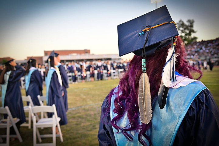 Behind view of a graduate's cap decorated with a Native American feather