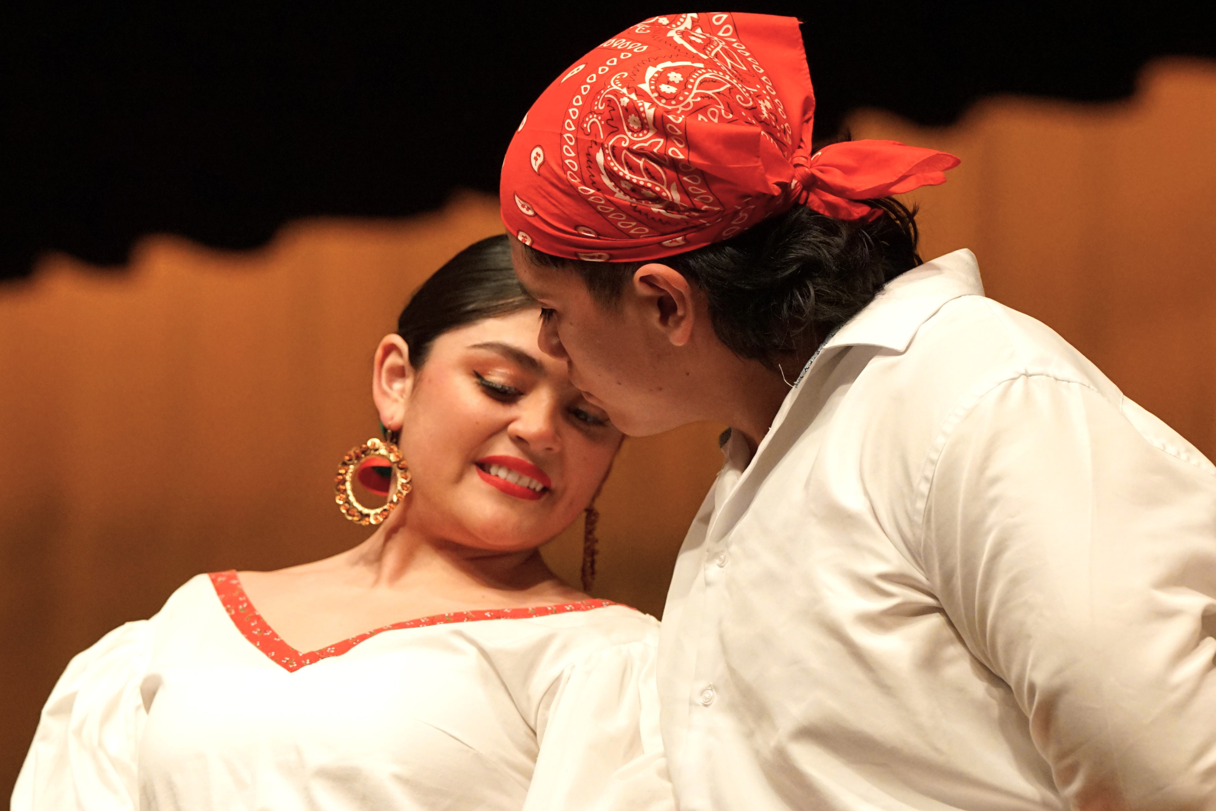 A girl and boy look at each other as they dance