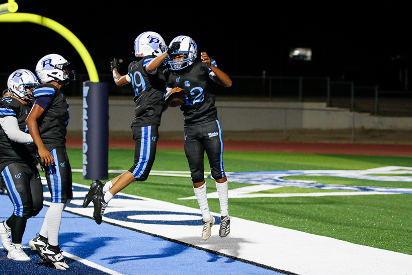 Two Pueblo football players chest-bump each other on the field
