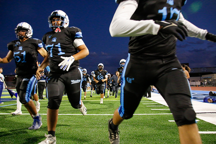 Pueblo football players run out onto the field