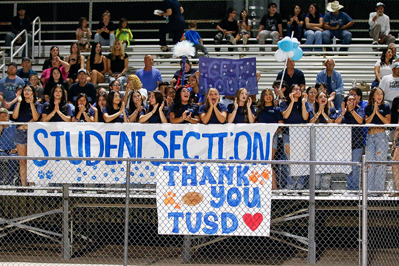 Students cheer in the stands behind a banner reading Student Section Thank You TUSD