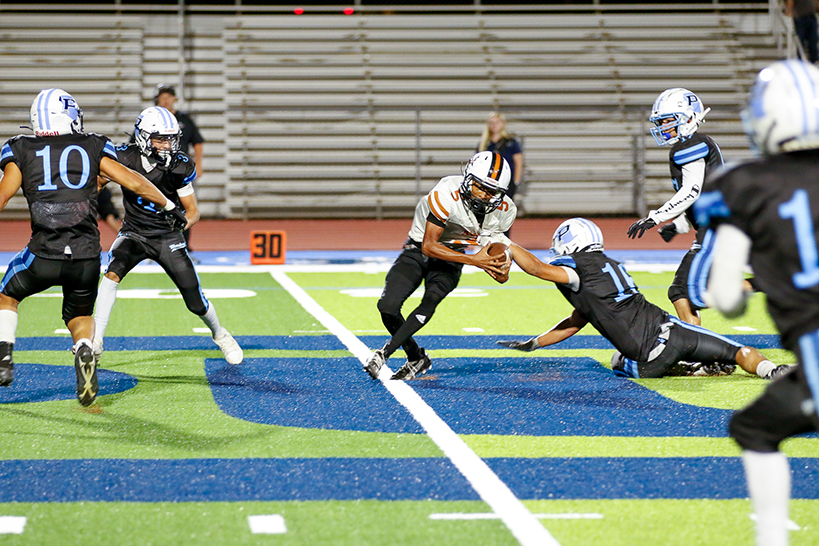 A Pueblo player dives on the field to try to steal the ball from an opponent