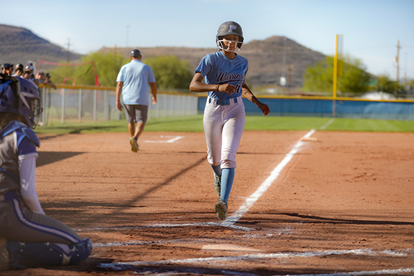 A teen girl runs around the bases during a softball matchup