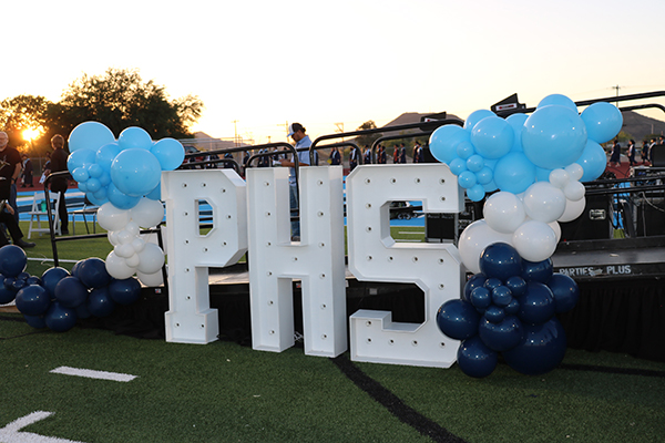 Big block letters reading PHS with blue balloons around it