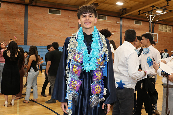 A graduate shows off his Takis sash