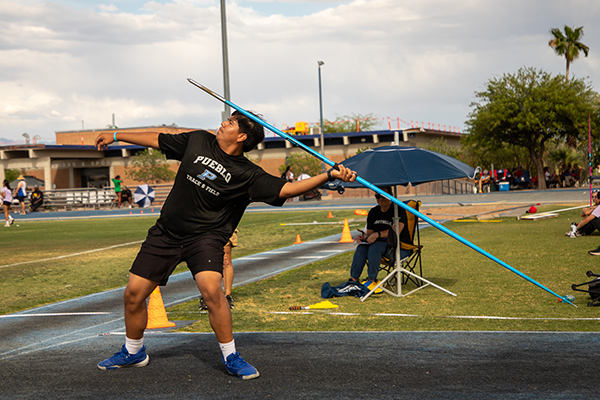 A teen boy throws a javelin
