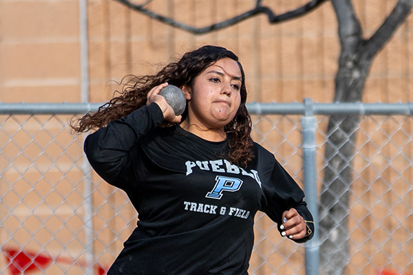 A teen girl throws a shotput