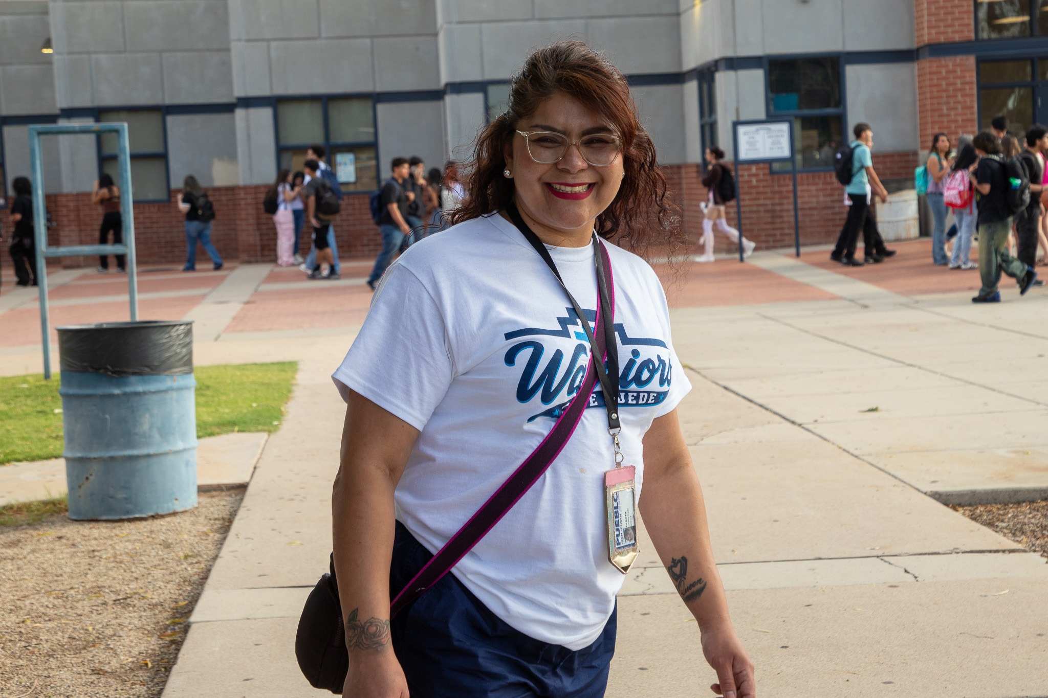 A woman smiles as she walks across campus